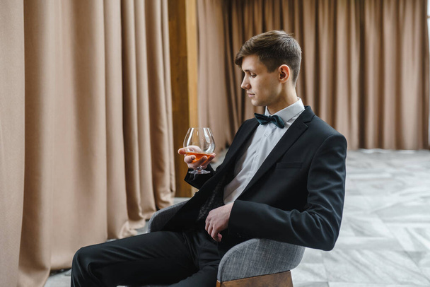 Un homme d'affaires tient un verre de vin
. - Photo, image