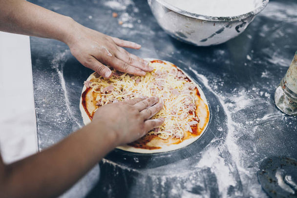 Közelkép a pizzakészítésről vagy az elkészítési folyamatról - Fotó, kép