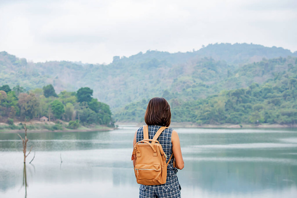 女性ショルダーバックパック背景山と水でワン・ボン・ダム｜Nakhon nayok, Thailand - 写真・画像