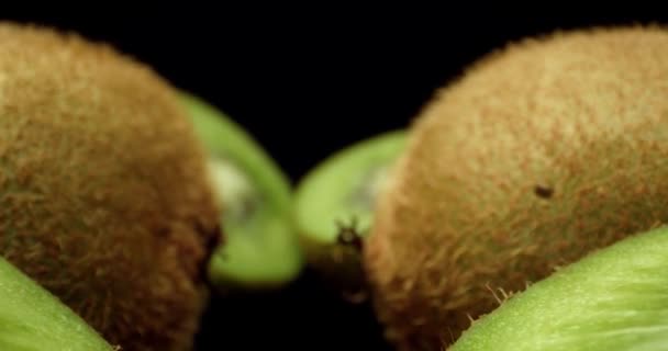 Zöld friss kivi gyümölcs vágott félig szuper makró közeli lövés légy felett 4k magas quallity lő sötét háttér - Felvétel, videó
