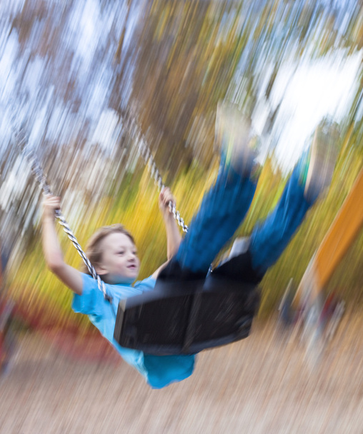 Хлопчик на гойдалці на дитячому майданчику
 - Фото, зображення