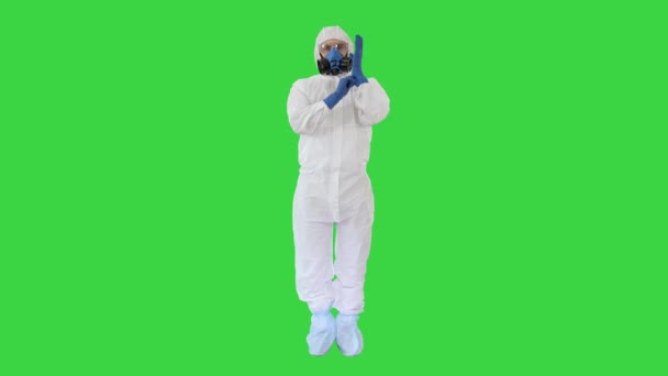 Людина, одягнена в захисний одяг ХаЗМАТ, показує, що він носить рукавички на зеленому екрані, Chroma Key. - Кадри, відео