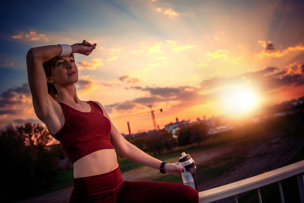 Retrato de mulher fitness após o treino na cidade. Fitness, esporte e conceito de estilo de vida saudável
. - Foto, Imagem