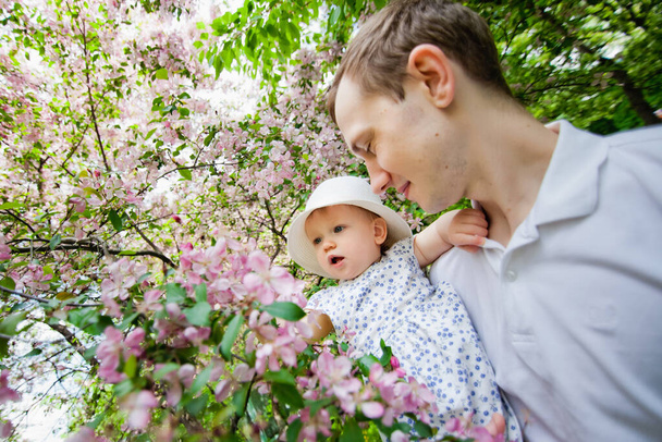 Tavasz van. Tavaszi szakuravirág. Boldog pár a Sakura Virágültetvényen. Turista családi séta a Sakura parkban. Boldog család a tavaszi kertben. Anya apa és kisfia együtt a virágzó sakura parkban.. - Fotó, kép