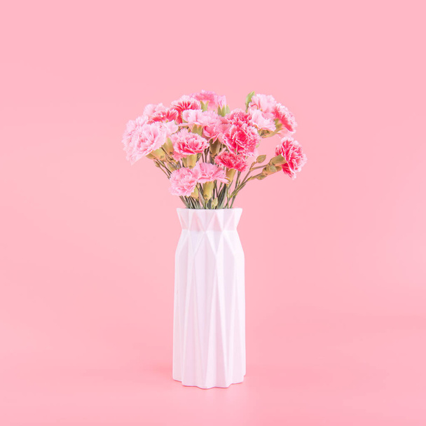 Mother's Day holiday gift design concept, pink carnation flower bouquet with greeting card, isolated on light pink background, copy space. - 写真・画像