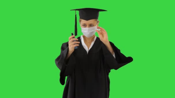 Απόφοιτος φοιτητής χρησιμοποιώντας απολυμαντικό να στεγνώσει τα χέρια της σε μια πράσινη οθόνη, Chroma Key. - Πλάνα, βίντεο