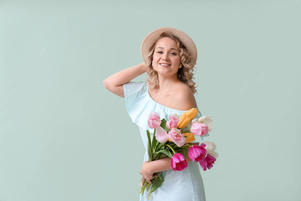 色の背景上の花の花束と美しい若い女性 - 写真・画像