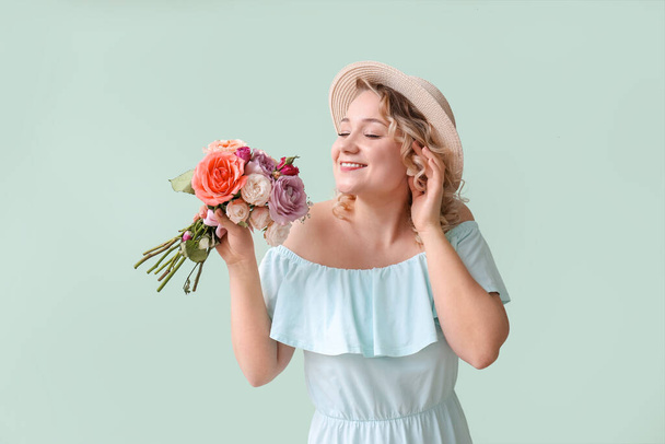 Mooie jonge vrouw met boeket bloemen op kleur achtergrond - Foto, afbeelding