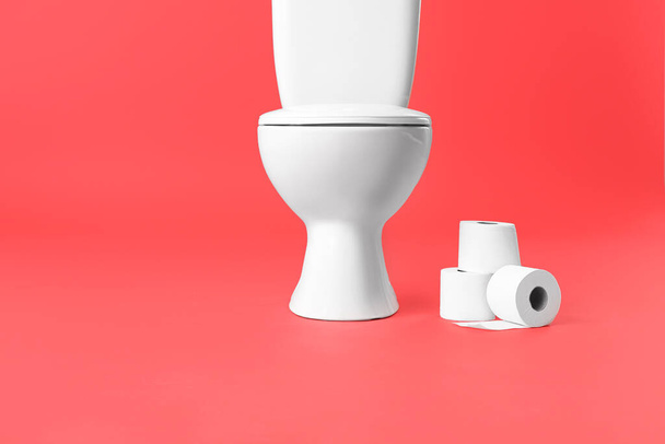Toaleta miska z rolkami papieru na tle koloru - Zdjęcie, obraz