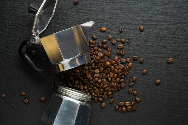 Composición de granos de café y cafetera moka sobre el fondo de piedra negra, vista plana
. - Foto, imagen