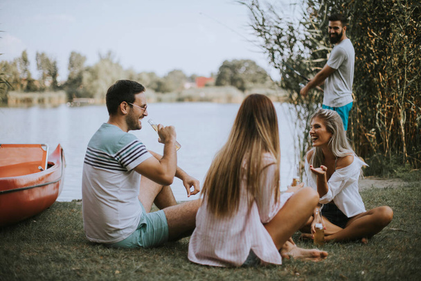 Група щасливих молодих друзів насолоджується природою на березі озера
 - Фото, зображення