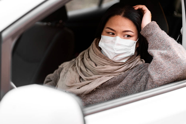 Woman protective mask driving car. Healthcare, virus protection. Taxi driver woman in mask - Fotó, kép