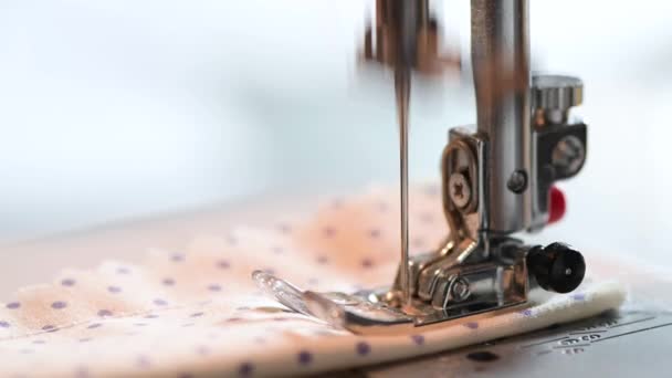 Detalle de una máquina de coser, pie con aguja e hilo cose un trozo de tela para máscara, respirador
 - Metraje, vídeo