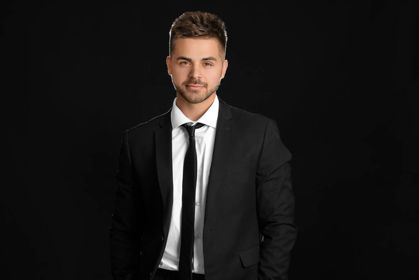 Portrait of handsome young businessman on dark background - Zdjęcie, obraz