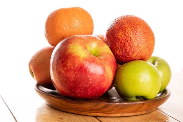 木のテーブルの上のリンゴとオレンジ - 写真・画像