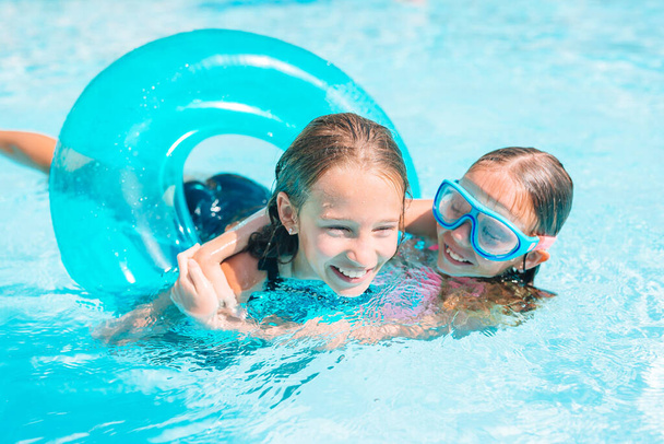 Roztomilé malé sestry hrát ve venkovním bazénu - Fotografie, Obrázek