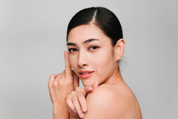 Beautiful asian woman ,young asian girl with clean and bright skin, Cosmetic Beauty Concept,hands touch on the cheek,smily and friendly face isolated on grey background - 写真・画像
