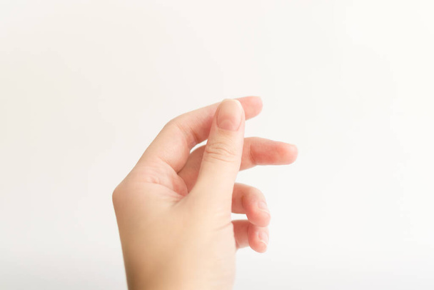 Nahaufnahme Frau Hand mit Nägeln Form von weichem Quadrat hält etwas in den Fingern. Weibchen behalten virtuelles Objekt. Nagelpflege zu Hause. Kopierraum - Foto, Bild
