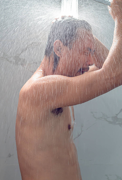 Asyalı adam banyoda duş alıyor.. - Fotoğraf, Görsel