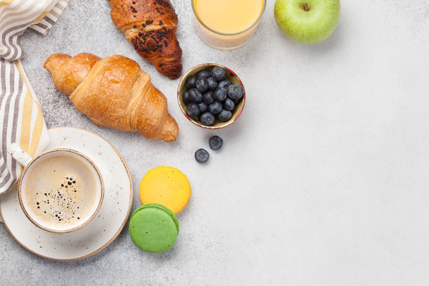 Desayuno con café, zumo de naranja y cruasán. Vista superior sobre mesa de piedra. Piso con espacio de copia
 - Foto, imagen