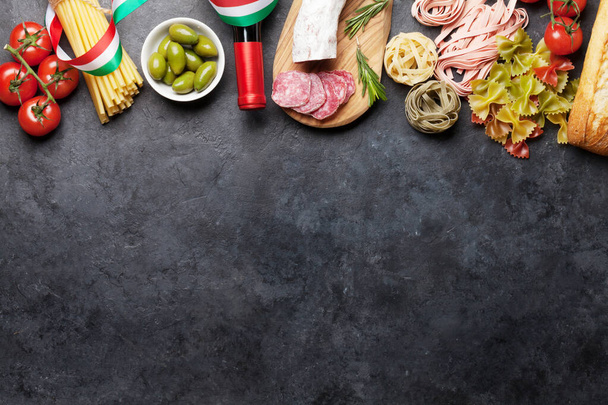 Italská kuchyně složky potravin. Těstoviny, sýr, salám, olivy a víno. Horní pohled byt ležel na kamenném stole s kopírovacím prostorem - Fotografie, Obrázek