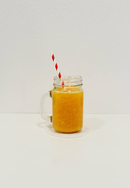 стакан апельсинового сока с вертикальной соломой
 - Фото, изображение