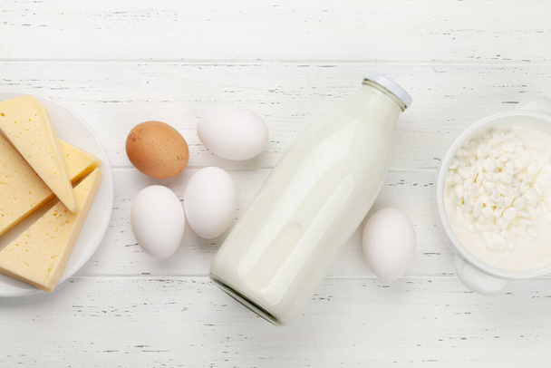 Milchprodukte, Milch, Hütte, Käse und Eier auf einem Holztisch. Draufsicht mit Kopierraum. Flache Lage - Foto, Bild