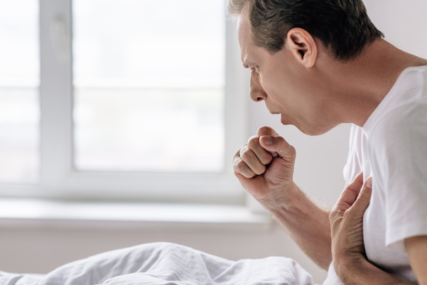 病気の男性が自宅で咳をしている様子を  - 写真・画像