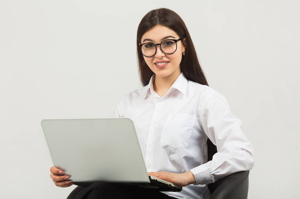 beautiful young woman in glasses on a white background with a laptop - Valokuva, kuva
