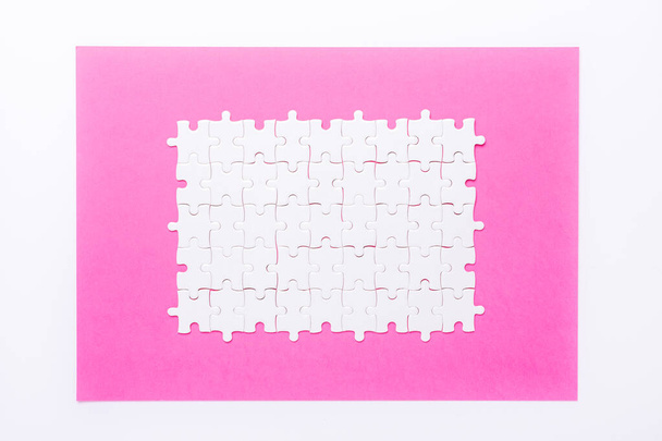 White details of puzzle on pink background Concept success of business - Image - Fotografie, Obrázek