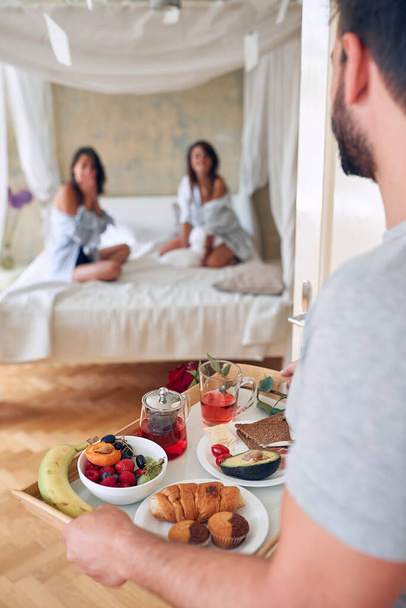 ゲイカップル女の子でベッドで一緒に朝食を持っている. - 写真・画像