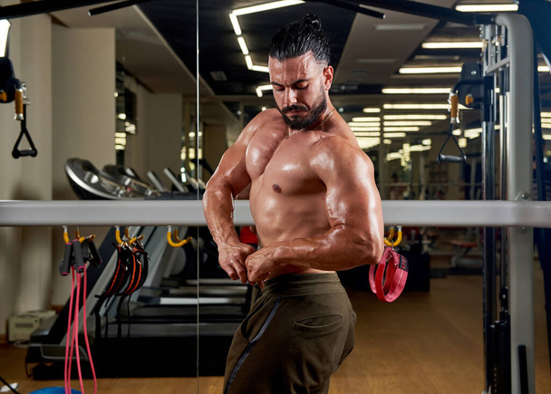 muscular man lifting weights, muscular man is training in gym - Fotografie, Obrázek