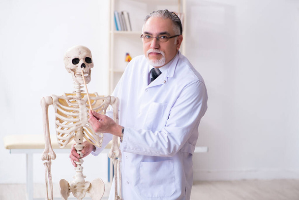 Homme âgé médecin avec squelette - Photo, image