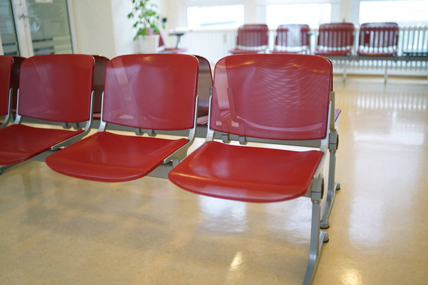 Sala d'attesa con sedie rosse e pavimento in linoleum beige
 - Foto, immagini