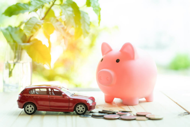 Hucha con monedas y coche, ahorrando dinero para el préstamo en línea
. - Foto, Imagen