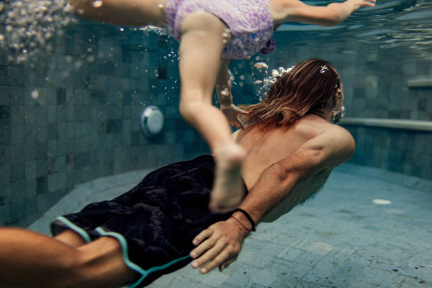 father and daughter swimming together in pool - Valokuva, kuva