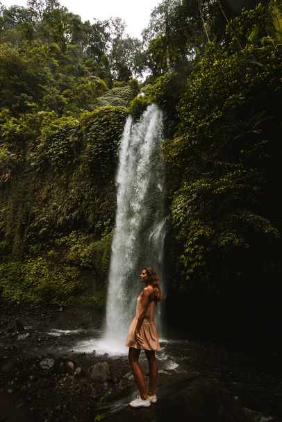 a girl poses in a bikini in a waterfall in a forest in bali - Zdjęcie, obraz