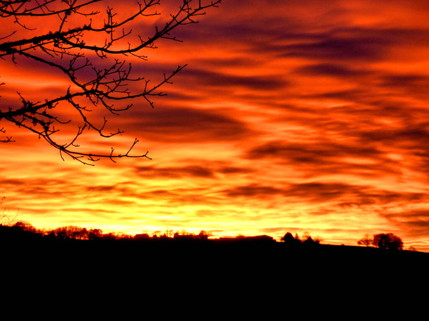 Auringonlasku Dordognessa, Ranskassa näyttää kuin taivas olisi tulessa.
 - Valokuva, kuva
