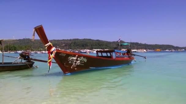 Ao Nang, Tajlandia - 24 stycznia 2020: Bamboo Wyspa jest popularnym miejscem turystycznym, więc tradycyjne łodzie longtail często przynoszą tu wczasowiczów do kąpieli i relaksu na plaży Bamboo - Materiał filmowy, wideo