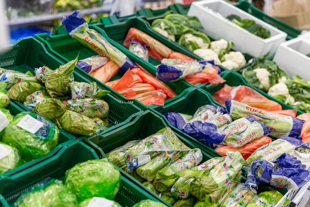 Moscow, Russia, 04/29/2020; Boxes with various vegetables in brightly colored packaging at a supermarket. Side view.  - Foto, Bild