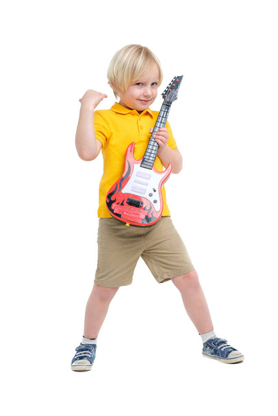 Boy plays on toy guitar isolated on white - Photo, Image