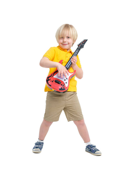 Boy plays on toy guitar isolated on white - Foto, Imagen