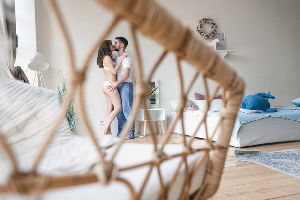 Woman and a man kiss in their bedroom - Foto, immagini