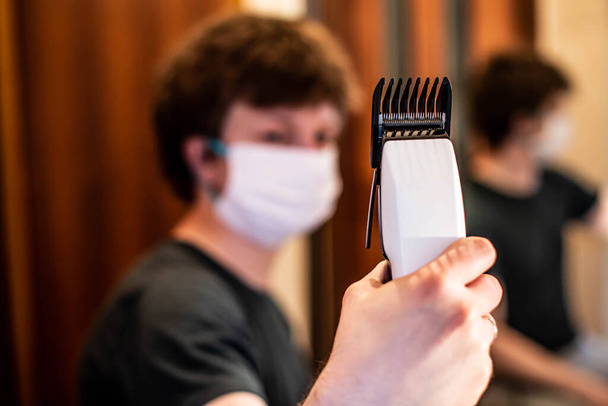  Haareschneiden zu Hause Selbstschneider in medizinischer Maske - Foto, Bild
