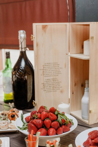 Schöne Urlaubstafel. Tisch gedeckt. Champagner-Erdbeeren und Snacks auf dem Tisch. Hochzeitsfeier - Foto, Bild