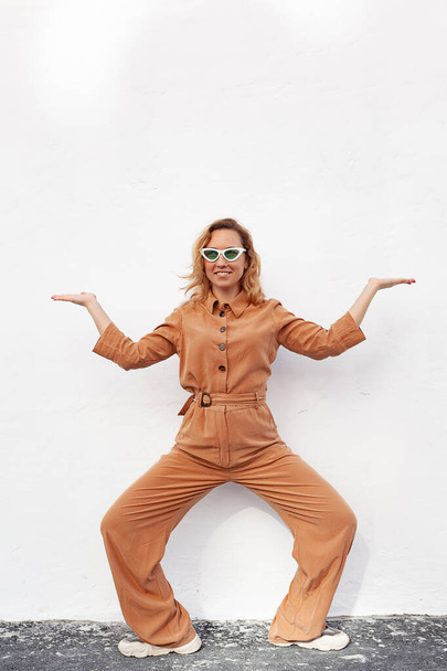 A young woman in a strange funny pose on a white background - Photo, Image
