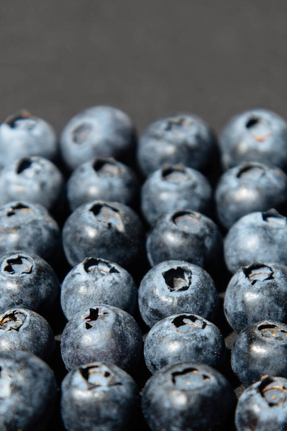 Blueberry antioxidante superalimento orgânico em conceito para alimentação saudável e nutrição. Mirtilos em fundo cinza
 - Foto, Imagem