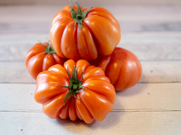 vier Tomaten auf einem hellen Tisch - Foto, Bild