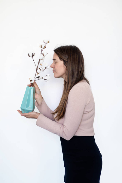 Portrait of a caucasian woman smelling a plant - Foto, imagen