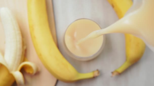 Banánturmix, banánlé öntés, szelektív fókusz egy pohárba - Felvétel, videó